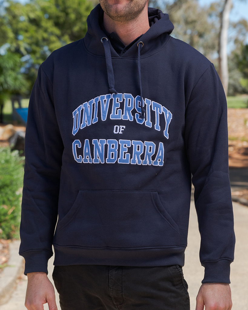 The torso of a male student. He is wearing a University of Canberra branded navy blue hoodie